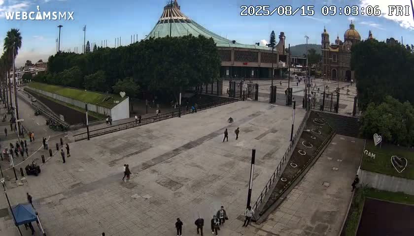 A large plaza with many people surrounds a grand basilica under an overcast sky.