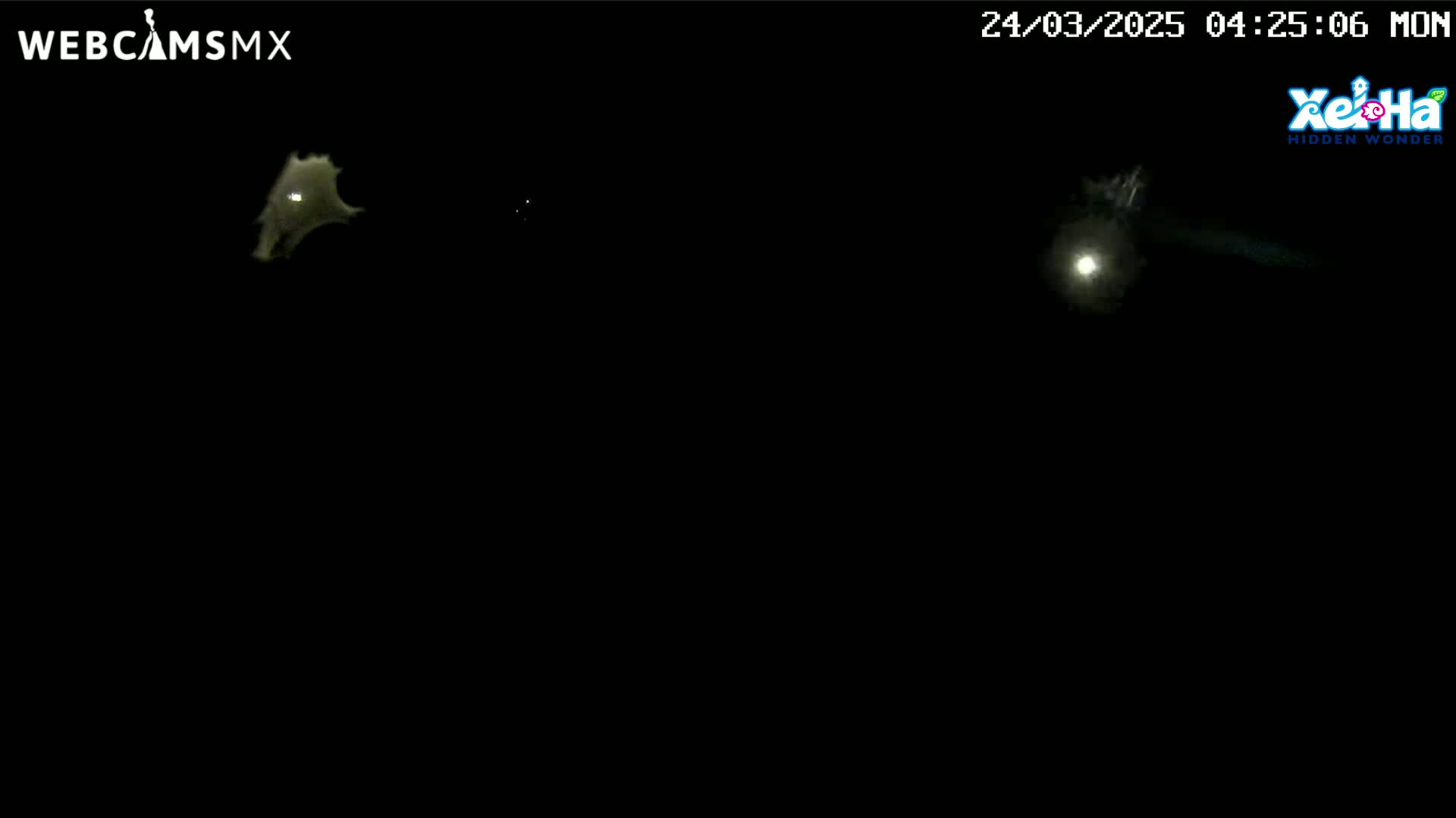 A nighttime, dark image shows two faint, bright objects in the distance.