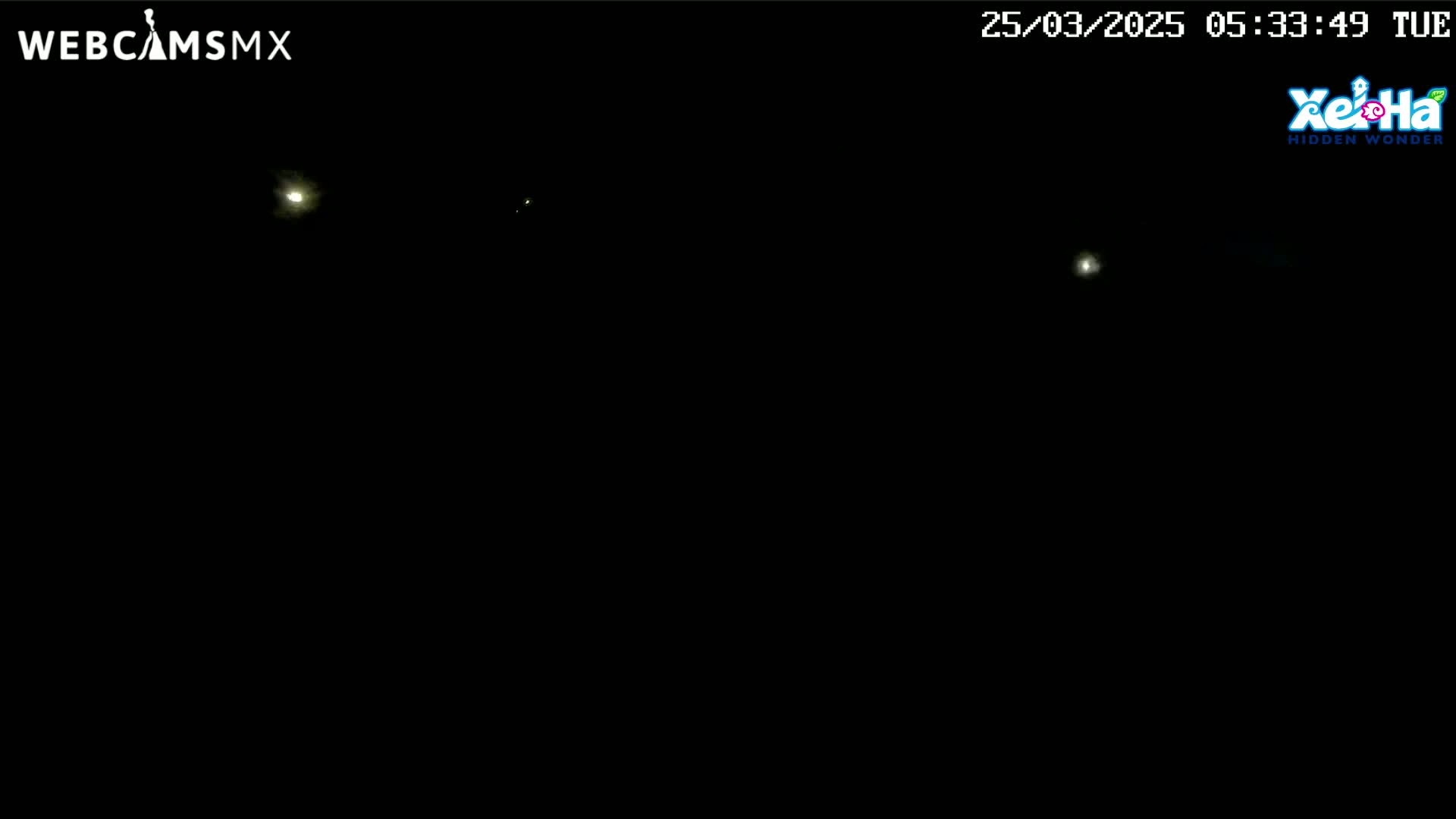 A nighttime image shows several distant lights in a completely dark sky.