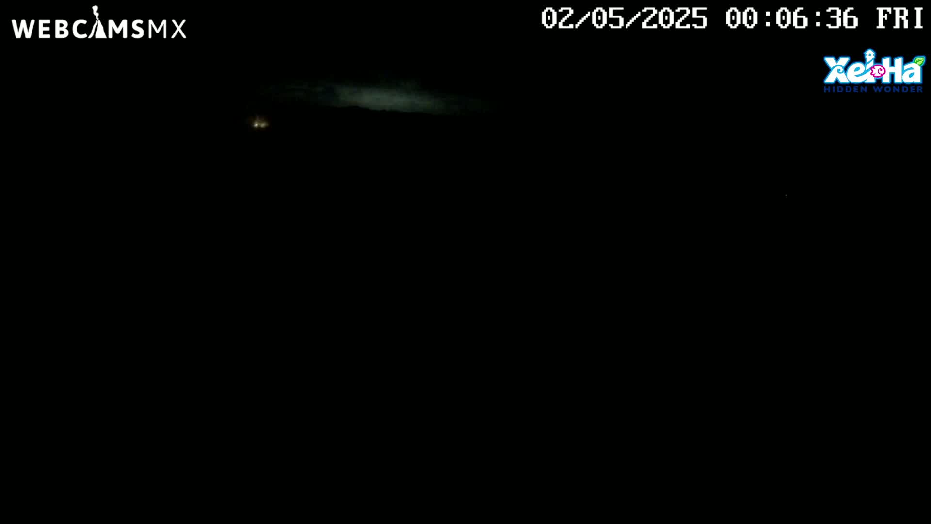 A dark, nighttime scene shows a faint, cloudy horizon with a few distant lights.