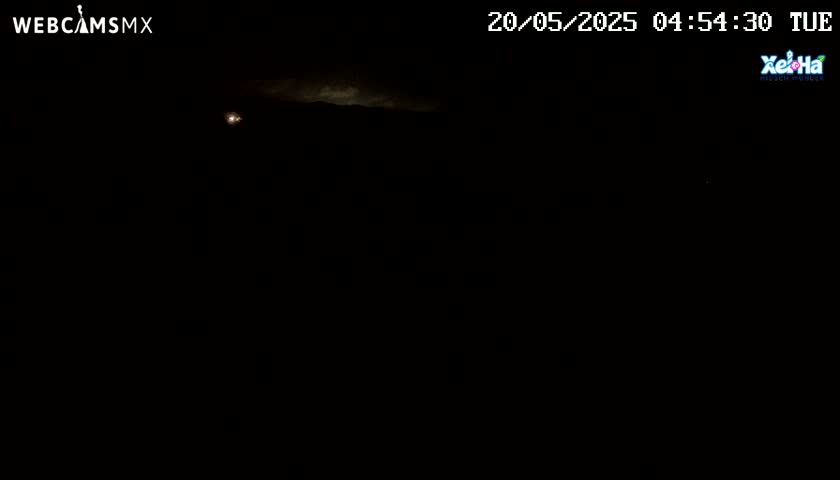 A mostly dark nighttime scene shows faintly lit clouds in the distance.