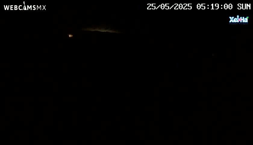A dark, nighttime scene shows a faintly lit horizon under a mostly clear sky.