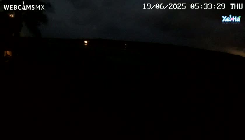 A dark, nighttime scene shows a mostly obscured landscape under a cloudy sky.