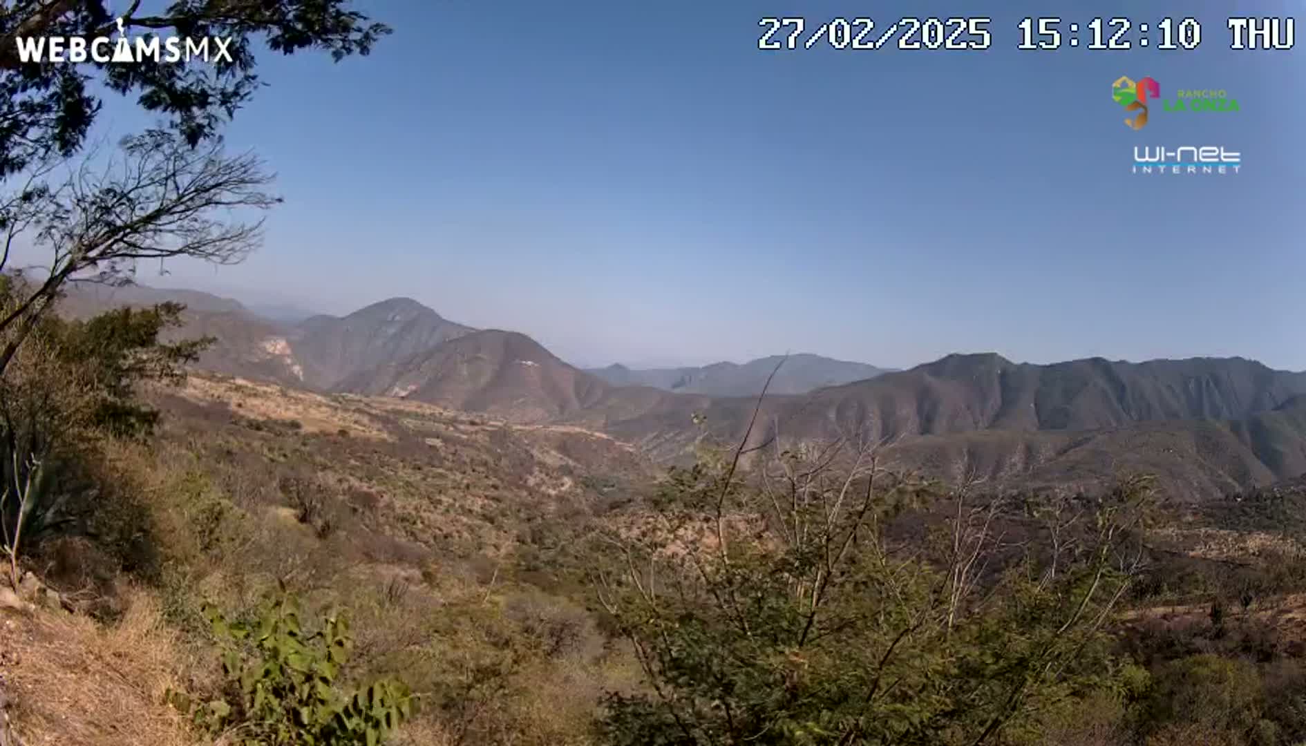 A view of a mountainous, arid landscape under a clear blue sky.