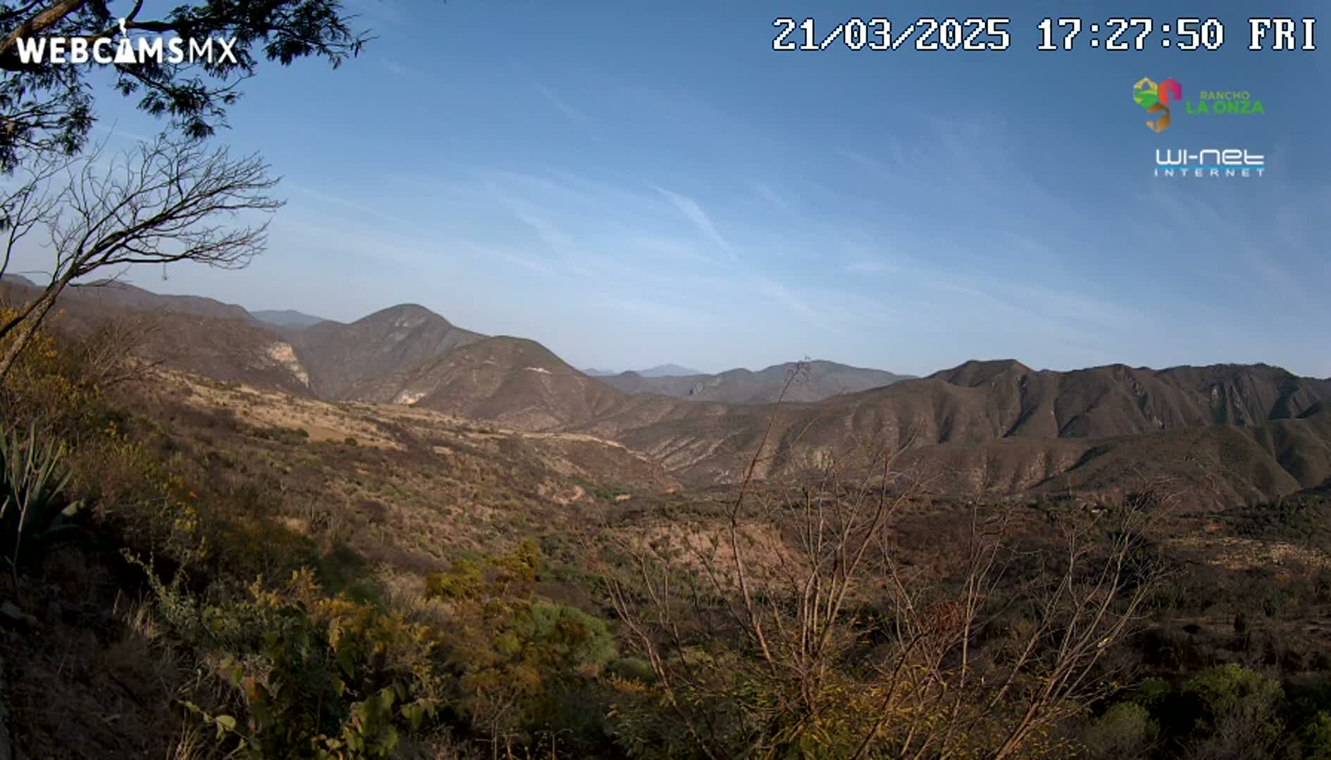 A view of a mountainous, dry landscape under a clear blue sky.