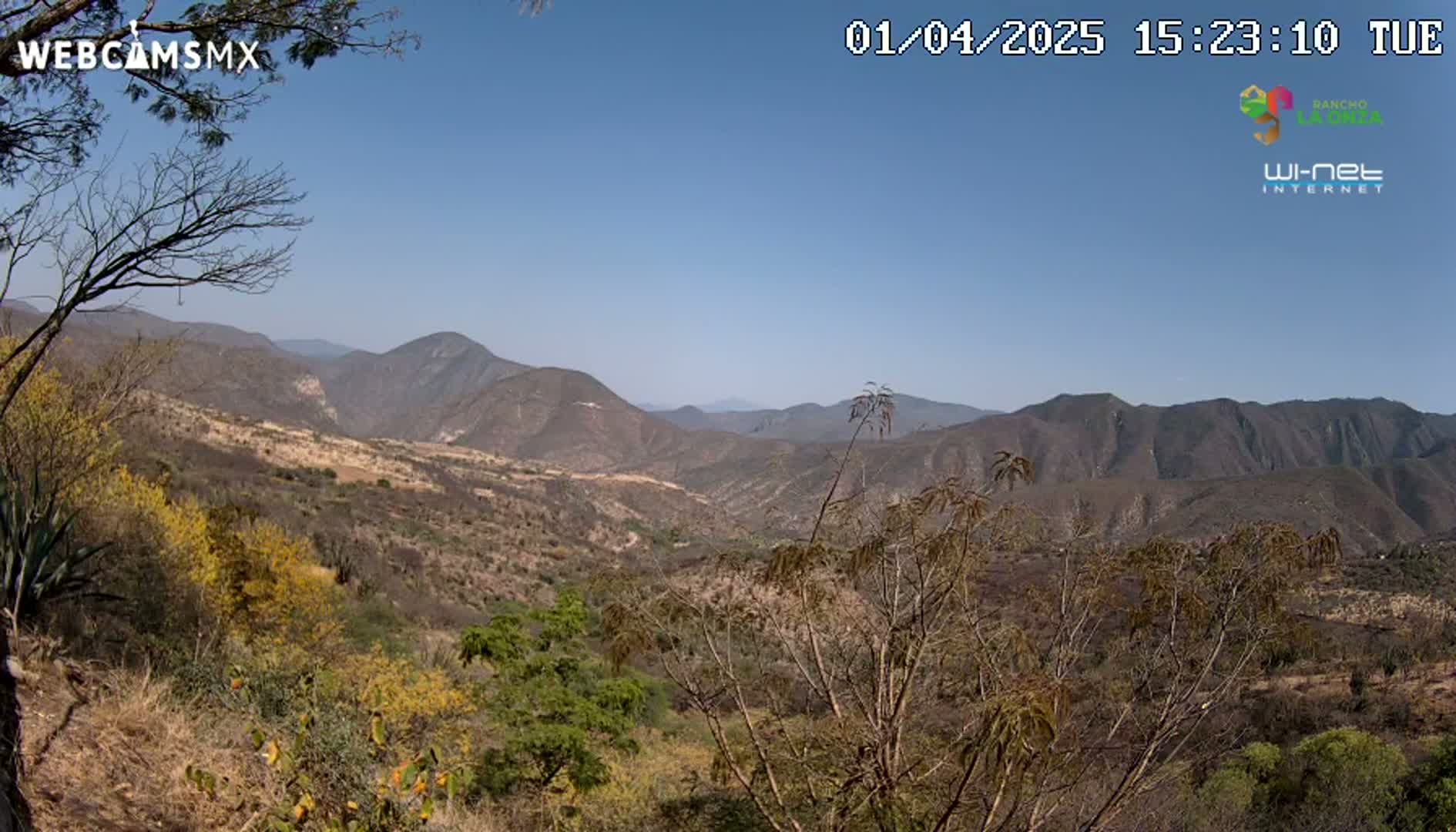 A view of a mountainous, arid valley under a clear blue sky.