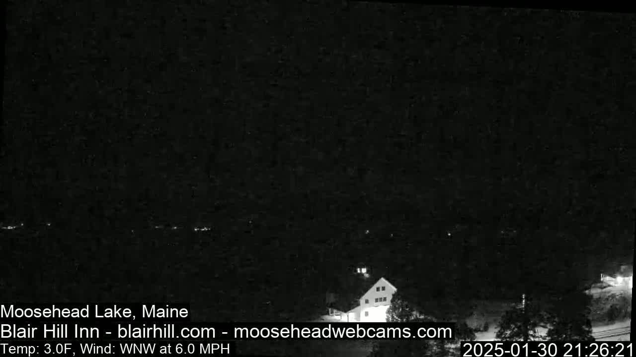 A nighttime, low-light view of a building near a body of water under a dark sky with a 6.0 mph wind from the west-northwest and a temperature of 3.0°F.