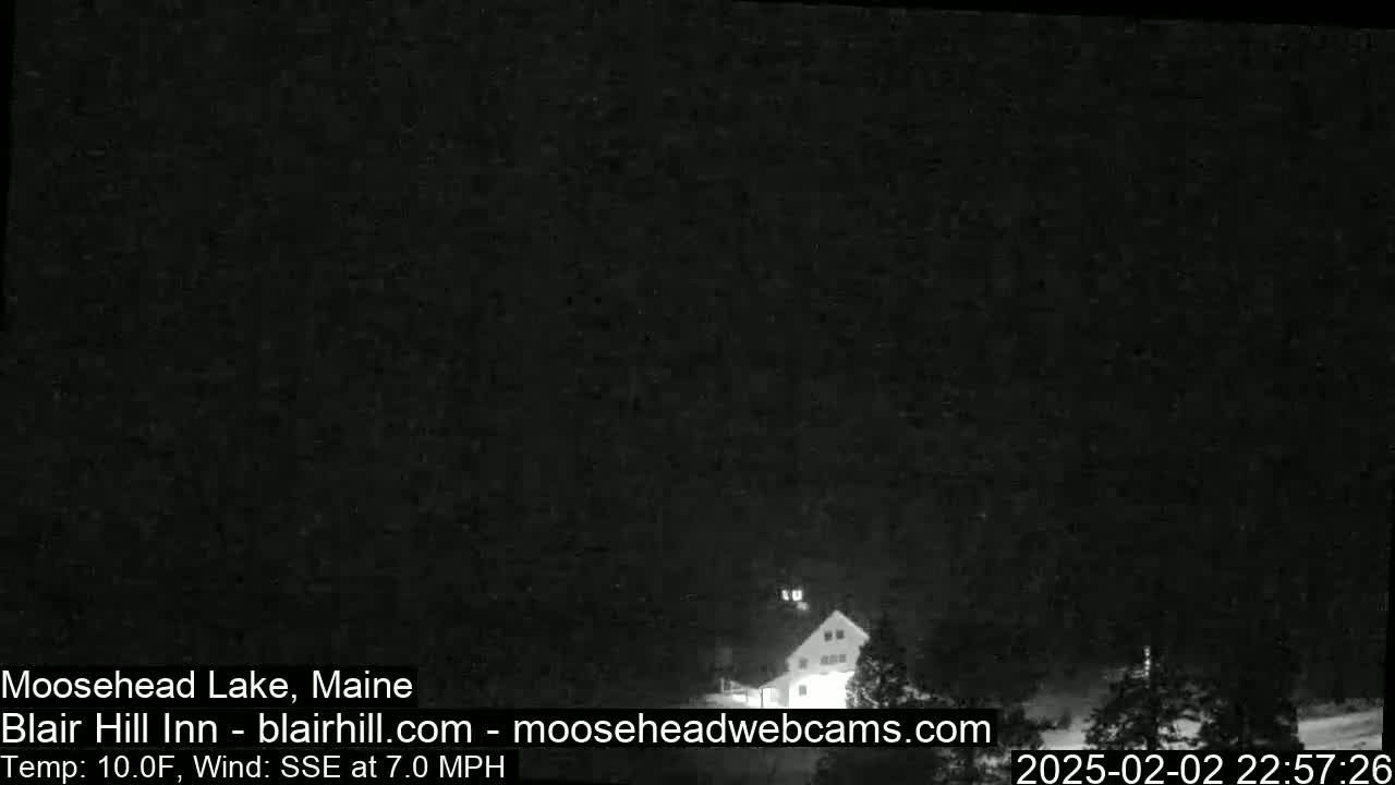 A nighttime, low-light image shows a building in a snowy area with a temperature of 10°F and a SSE wind at 7.0 mph.