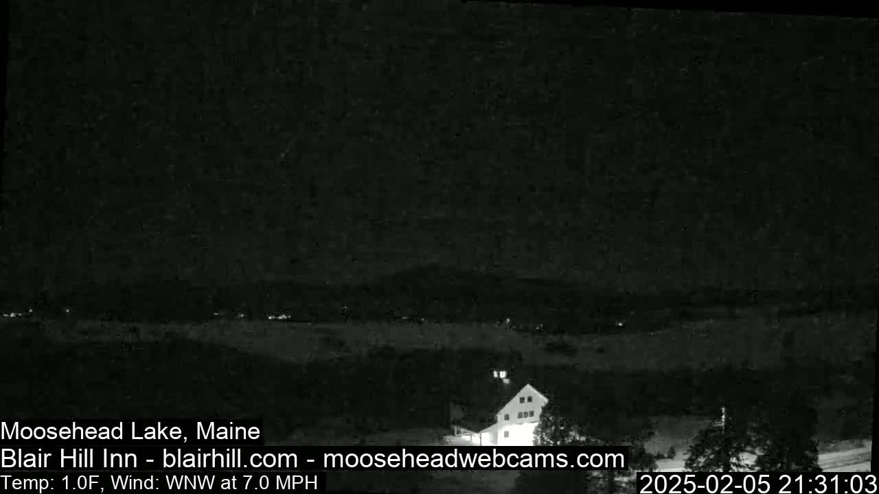 A nighttime, low-light view of a building and a dark landscape, with a WNW wind at 7.0 mph and a temperature of 1 degree Fahrenheit.