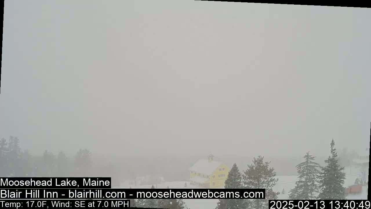 A snow-covered landscape with a yellow building is barely visible through heavy fog, with a southeasterly wind at 7 mph and a temperature of 17 degrees Fahrenheit.