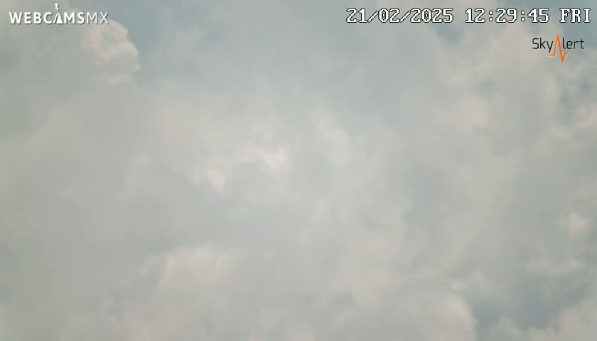 A mostly cloudy sky is visible with some areas of brighter clouds.