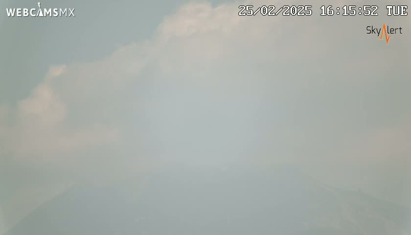 A hazy, cloudy outdoor scene is visible, with a mostly overcast sky.