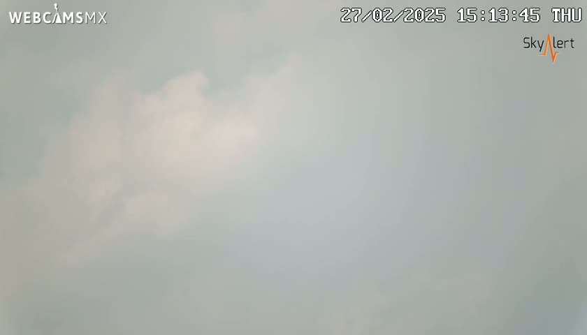A mostly cloudy sky is visible, with some patches of lighter clouds.