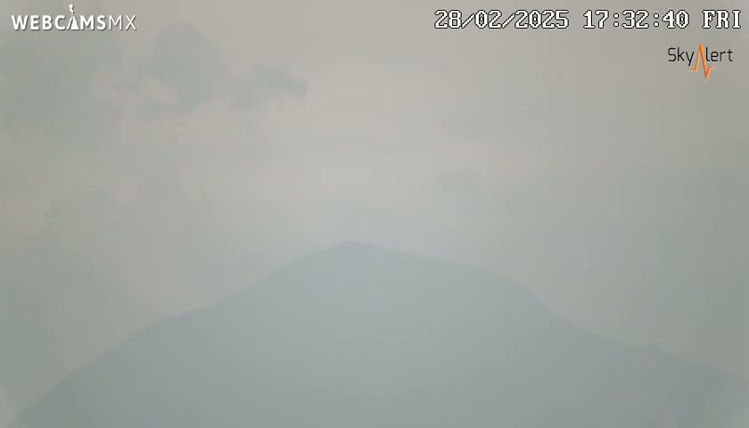 A hazy, overcast sky obscures a distant mountain range.