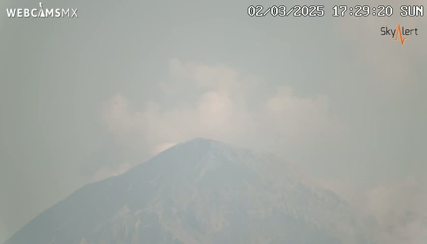 A hazy, cloudy sky obscures a distant mountain.