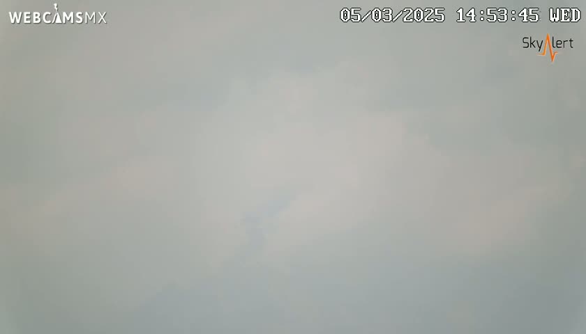 A mostly cloudy, hazy sky is visible.