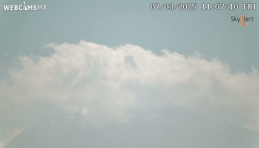 A mostly cloudy sky with a hazy layer obscuring the lower portion of the view.