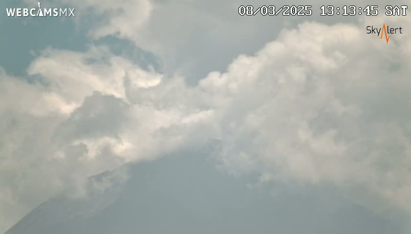 A partly cloudy sky obscures a mountain peak in the distance.
