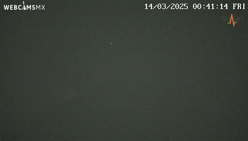 A dark, nighttime outdoor scene shows a mostly clear sky with a few faint lights visible.