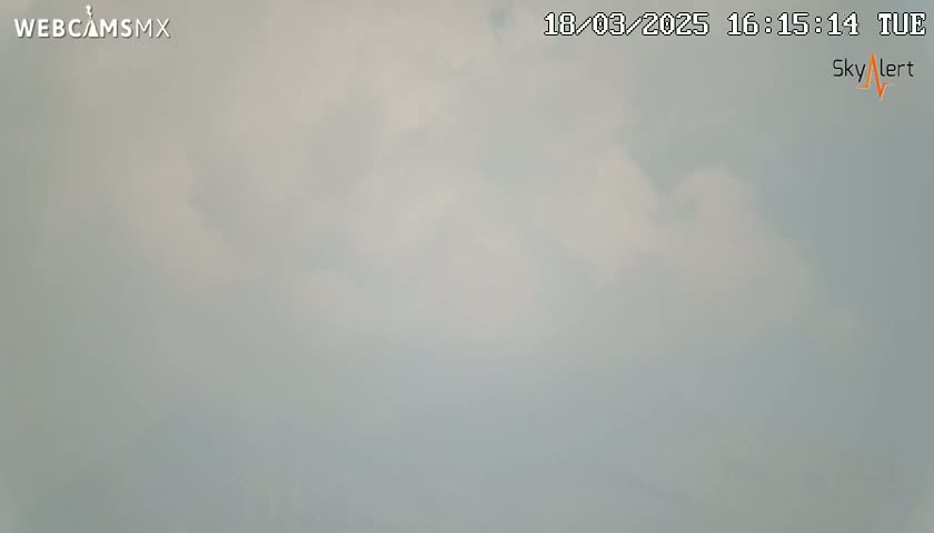 A mostly cloudy sky is visible outdoors.
