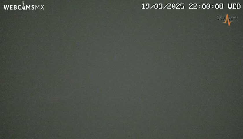 A dark gray or green solid-colored image shows a nighttime outdoor scene under cloudy conditions.