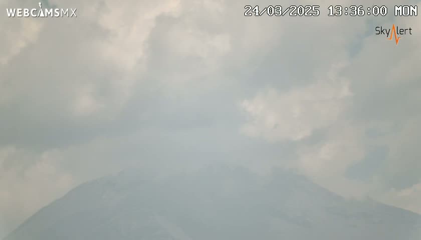 A hazy, overcast sky obscures a distant mountain range.