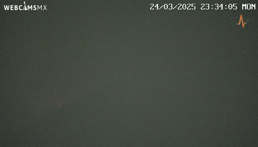 A dark gray or black, uniformly colored image shows a mostly clear night sky.