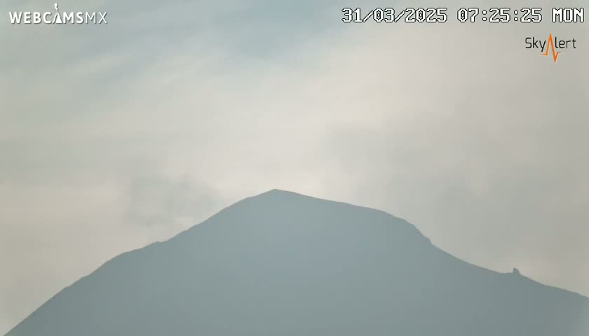 A hazy, overcast sky is visible above a dark, lone mountain.