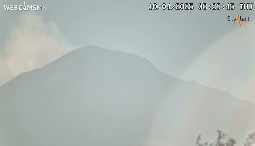 A hazy mountain range is visible under a cloudy sky.