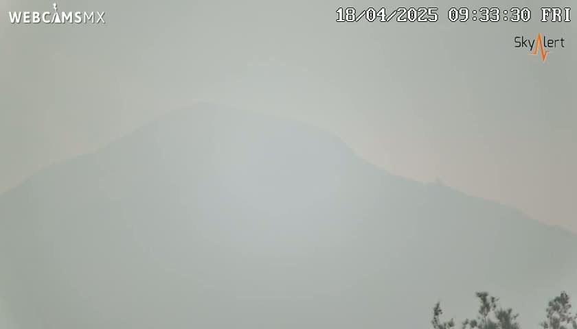 A hazy, possibly smoky, view shows a distant mountain range under a muted sky.