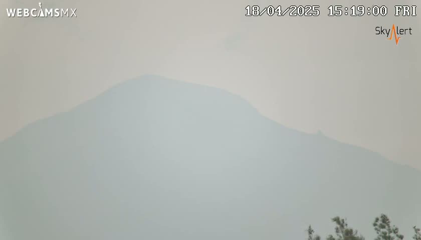 A hazy, light-grey mountain range is visible under a smoky sky.