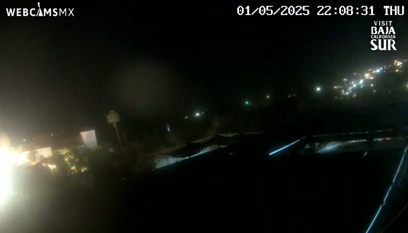 A nighttime view of a town with scattered lights, partially obscured by haze or fog.