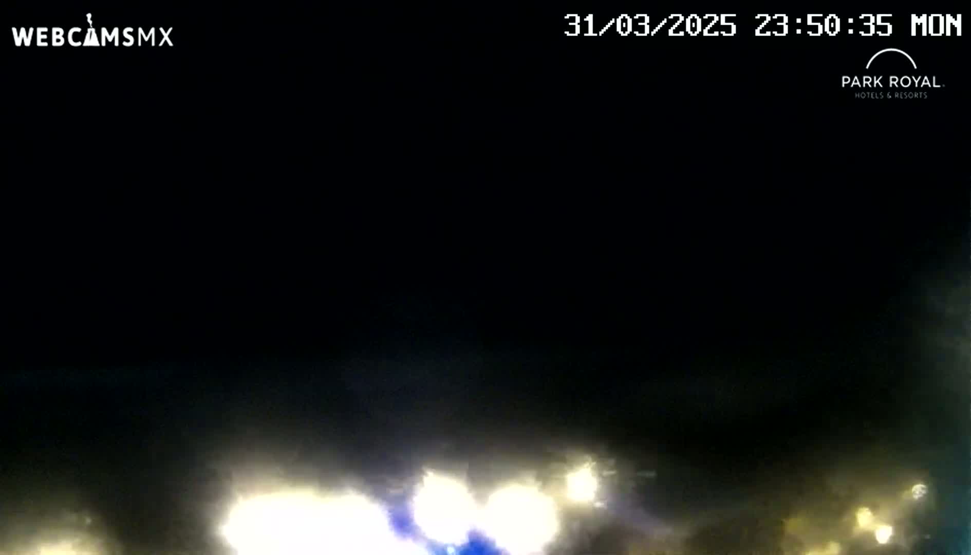 At night, hazy lights from vehicles are visible in the distance.