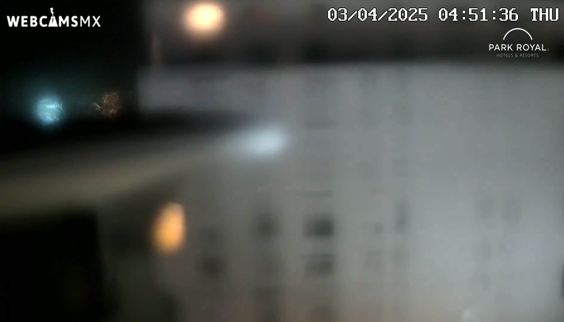 A blurry image shows an out-of-focus view of what appears to be a night scene with lights visible through a hazy or foggy lens.