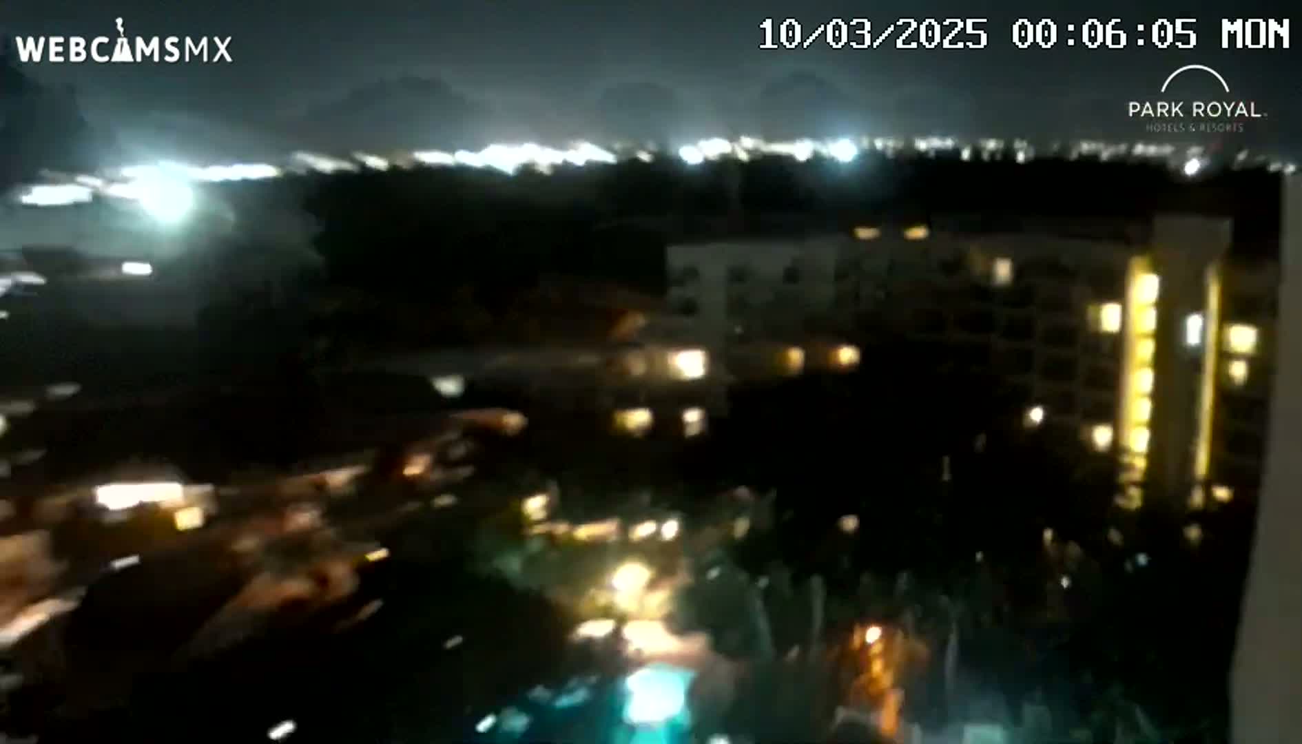 A nighttime view of a resort complex with its lights on, under a dark and possibly stormy sky.