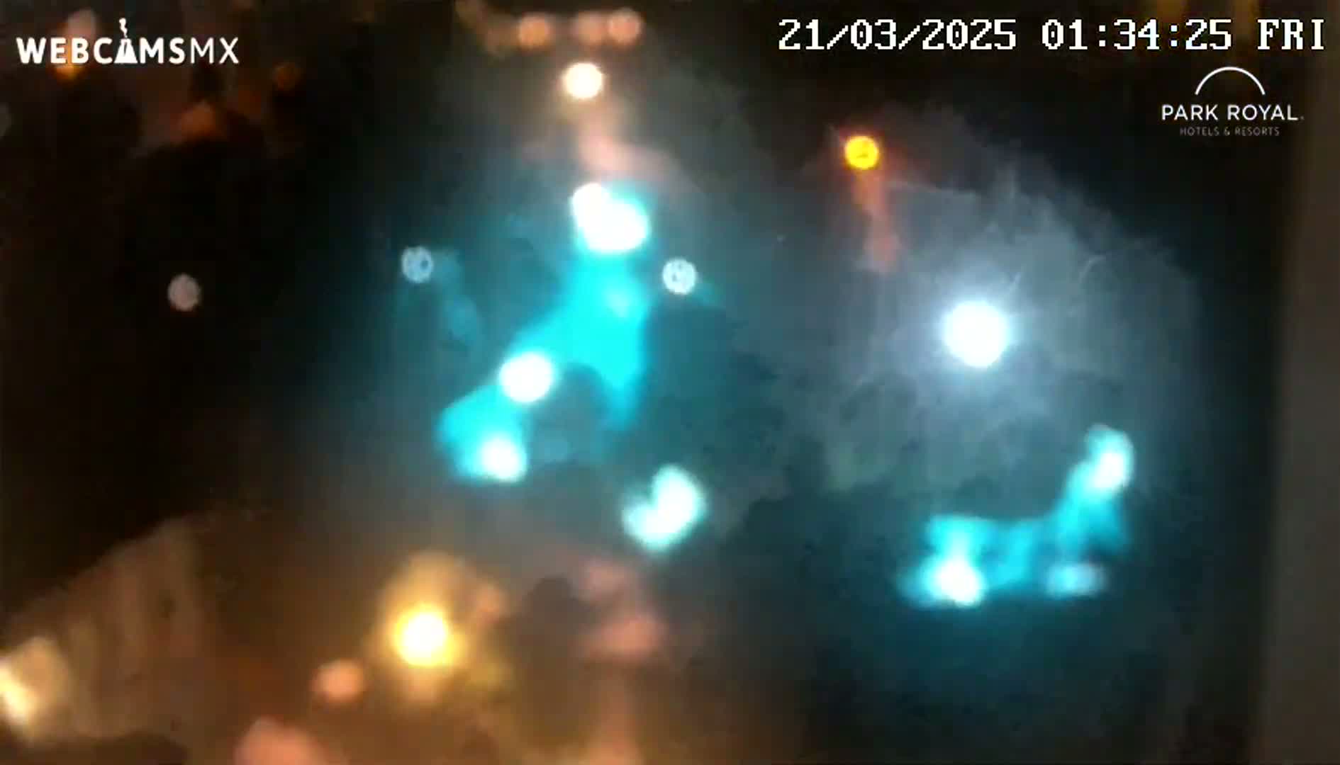 Blurry out-of-focus lights of various colors are visible at night.