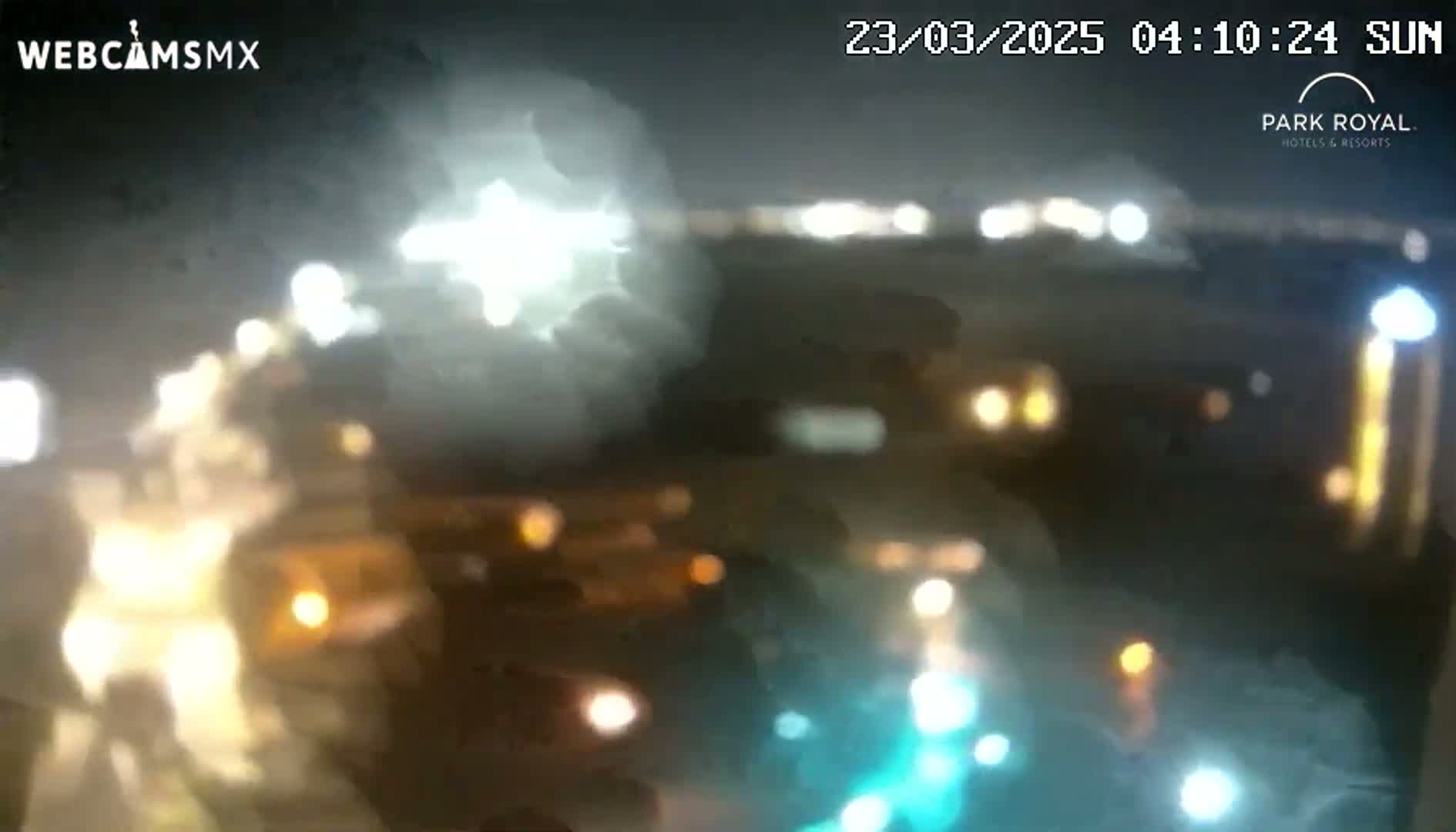 A blurry nighttime image shows out-of-focus lights from vehicles and buildings.