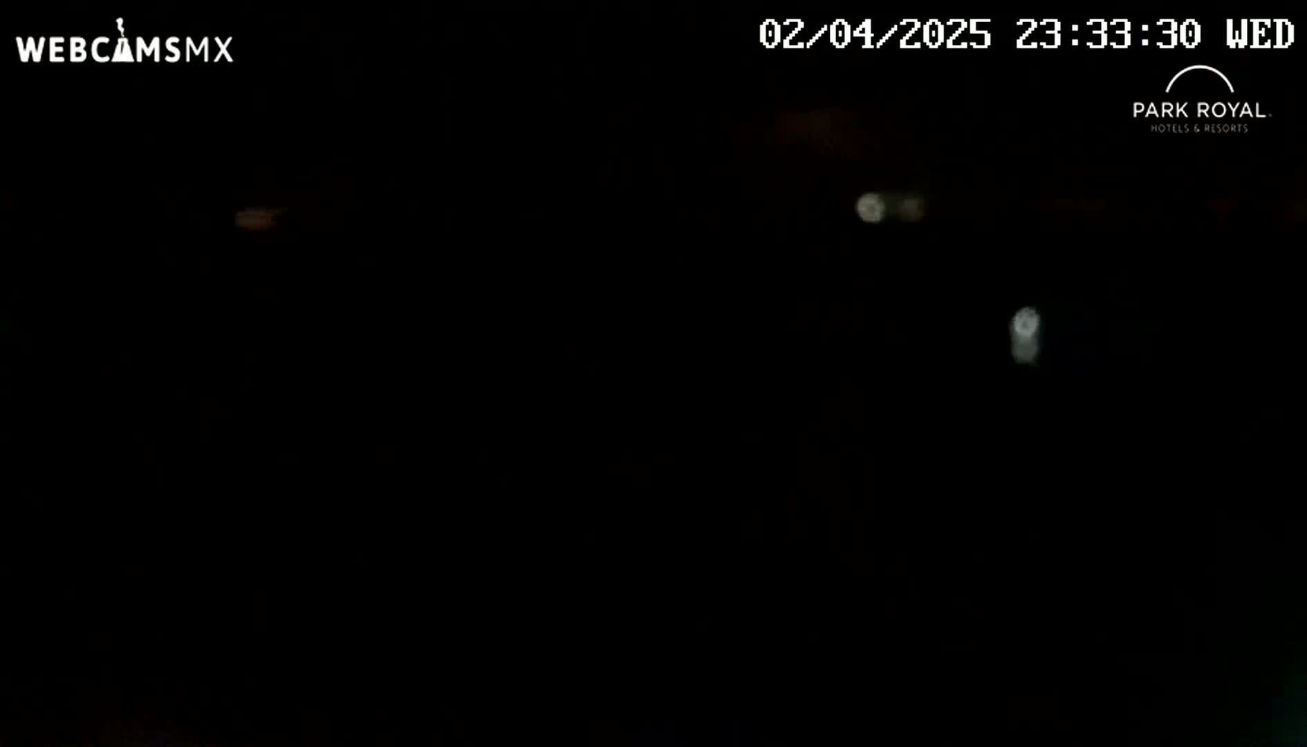 A nighttime image shows a very dark scene with a few indistinct bright spots.
