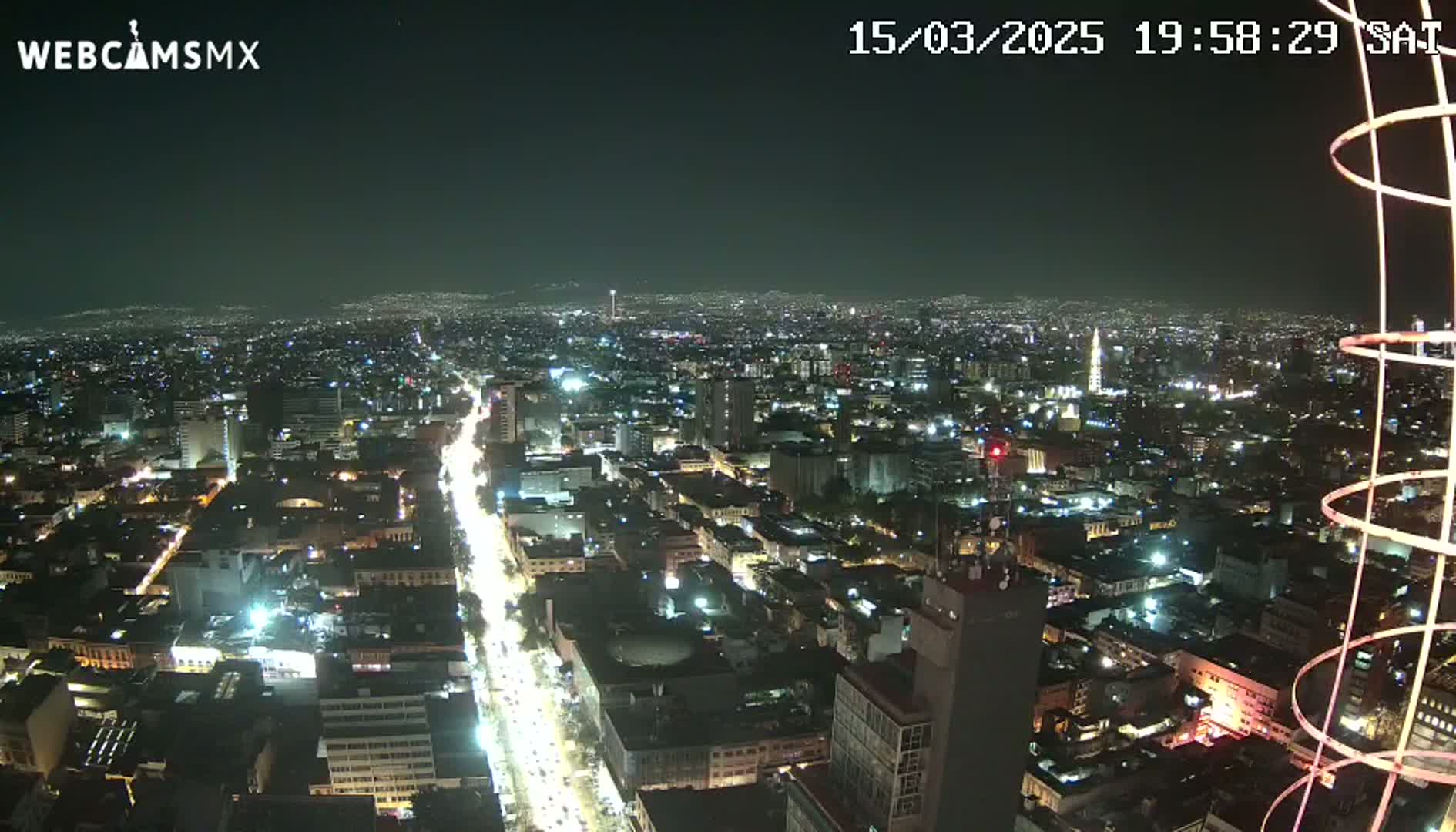 A nighttime, aerial view of a brightly lit city with a clear sky.