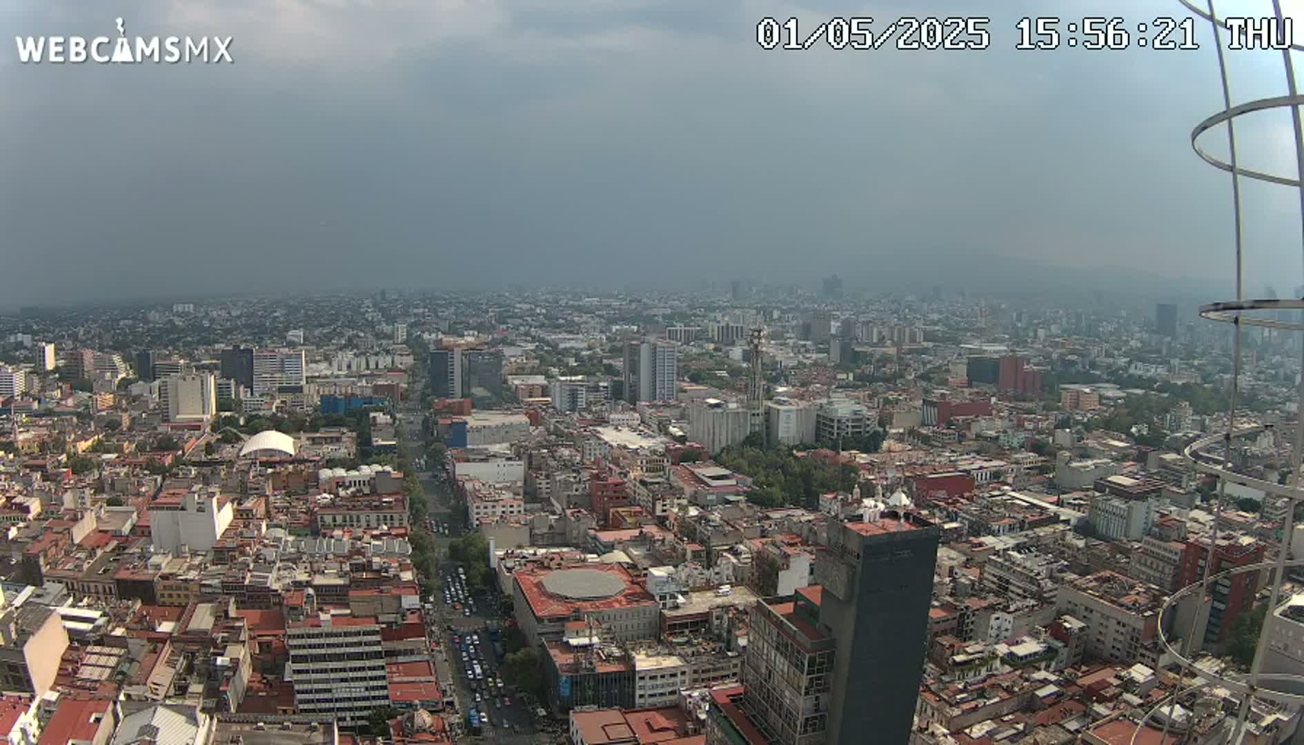 A hazy, overcast view of a sprawling city, seen from a high vantage point.