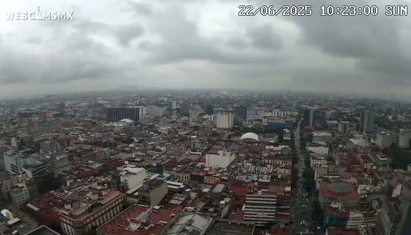 A high-angle view of a sprawling city under a cloudy, overcast sky.