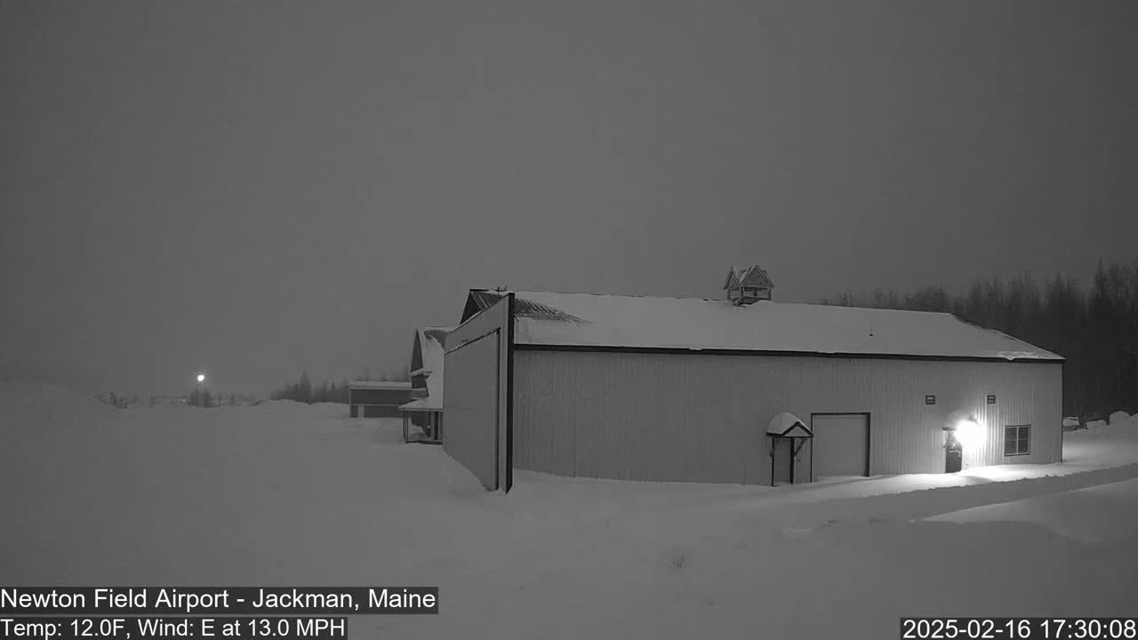A large, snow-covered building stands in a snowy landscape under a dark, overcast sky with an easterly wind at 13 mph and a temperature of 12°F.