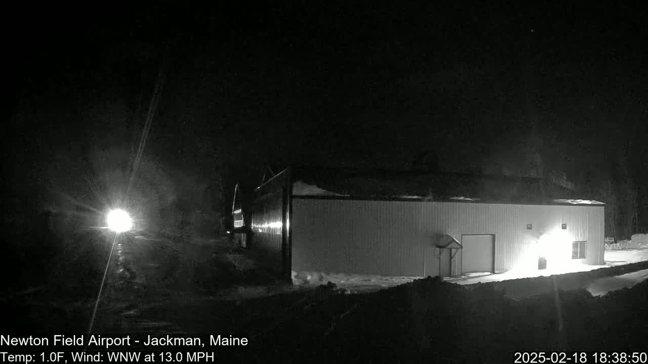 A long, white building is visible at night under a dark sky with a northwest wind blowing at 13 mph, and the temperature is 1 degree Fahrenheit.