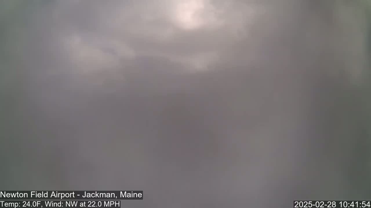 A mostly overcast sky with a faint hint of sunlight is visible, under conditions of 24°F and a 22 mph northwest wind.