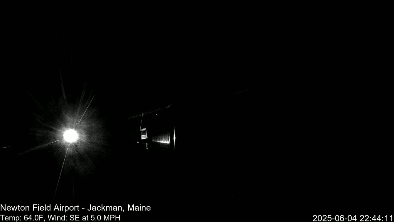 A bright light shines in the darkness, illuminating a building in the foreground with a southeast wind at 5 mph and a temperature of 64°F.