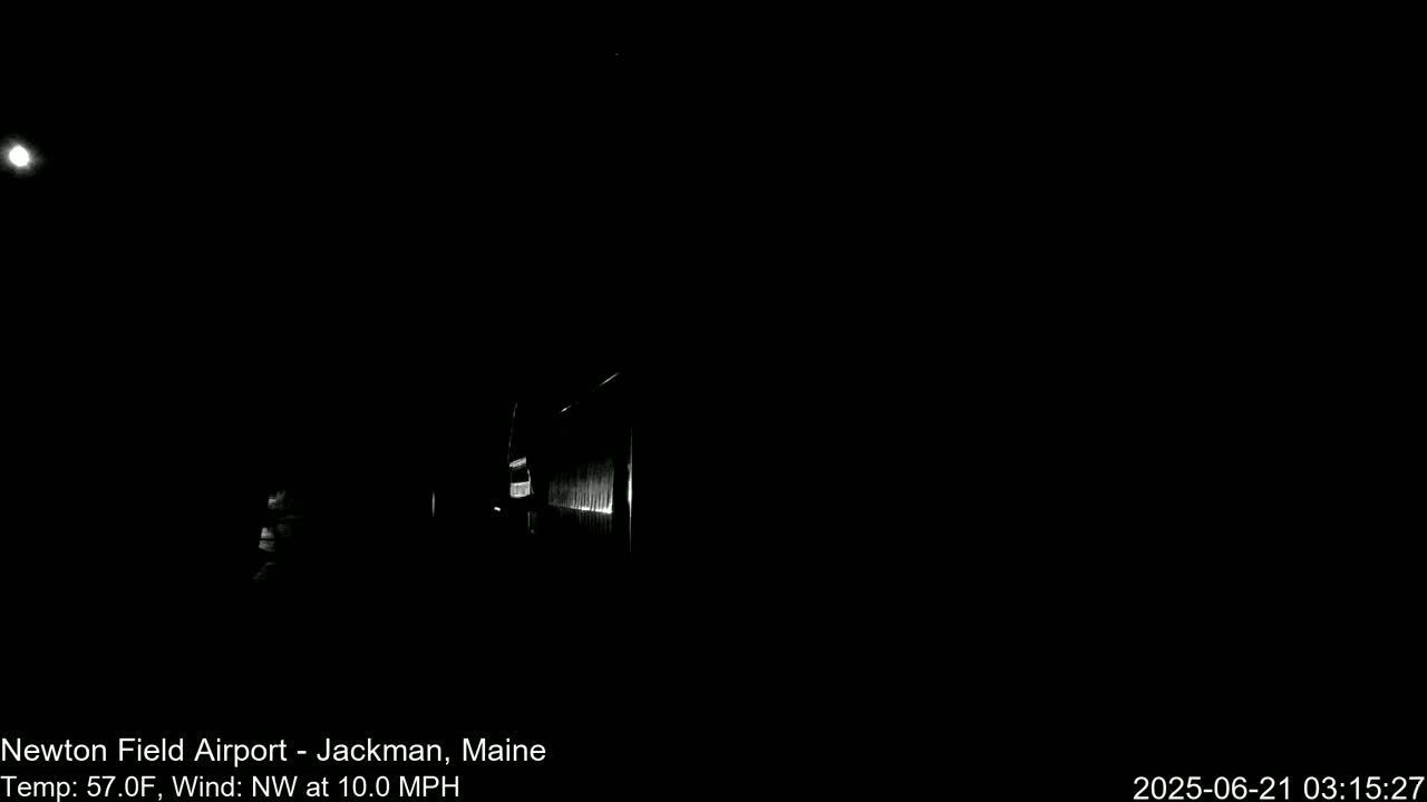 A dimly lit structure is visible at night under a dark sky with a bright moon and a northwest wind of 10 mph at 57°F.