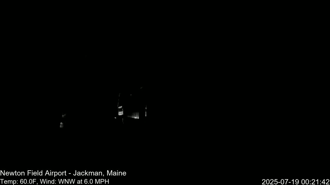 A dimly lit building is visible in the darkness of night, with a 60°F temperature and a 6.0 MPH wind blowing from the west-northwest.