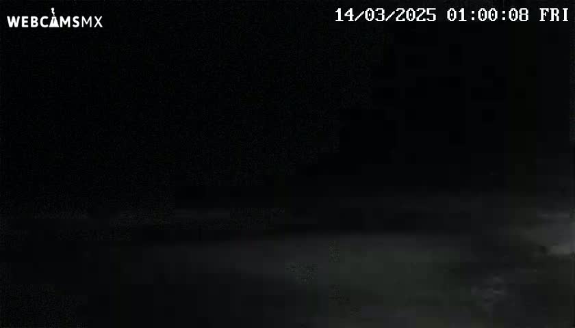 A dark, nighttime scene shows a mostly obscured view of a flat, possibly paved, surface.