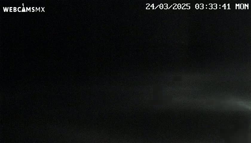A dark nighttime scene shows a faint, light source in the distance.