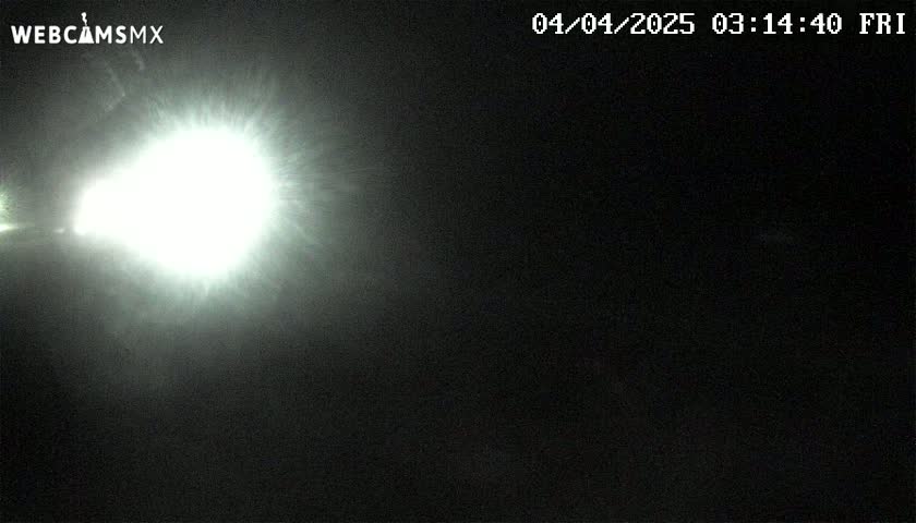 A bright light source dominates the left side of a dark, nighttime image.
